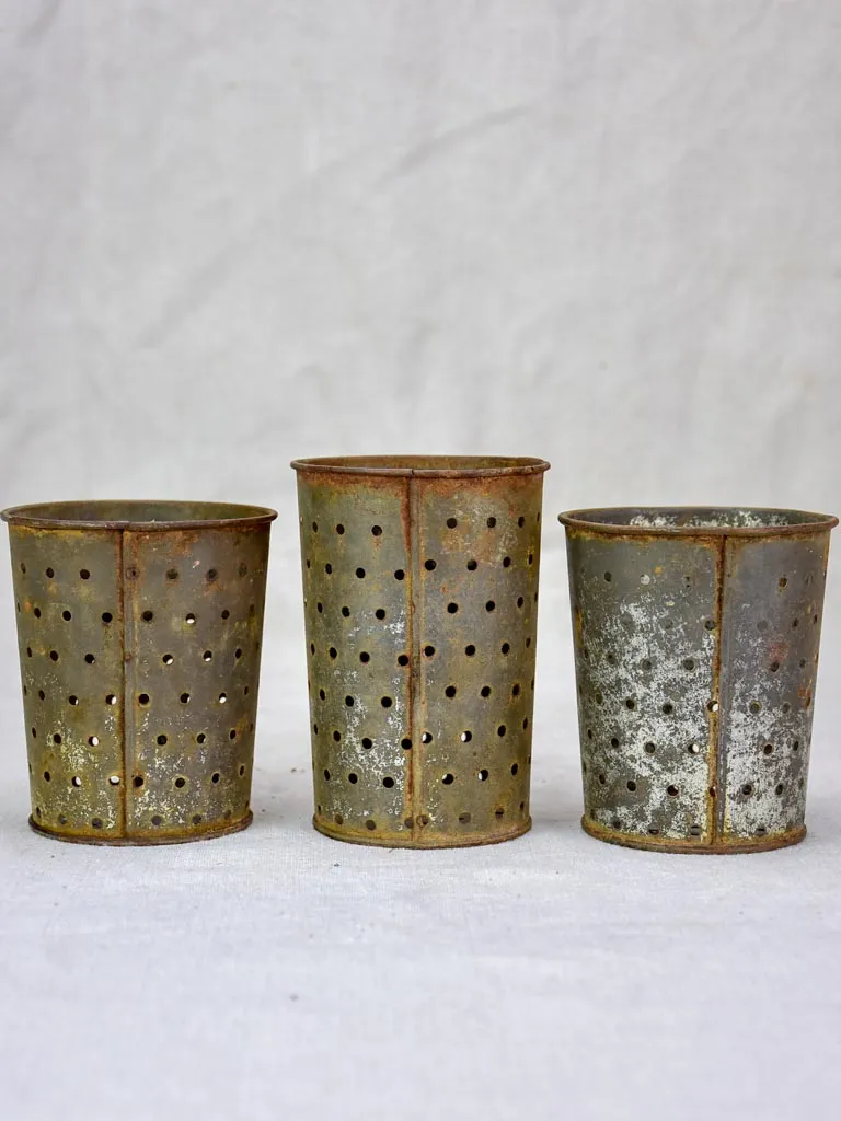 Collection of three tin cheese strainer molds / faisselles